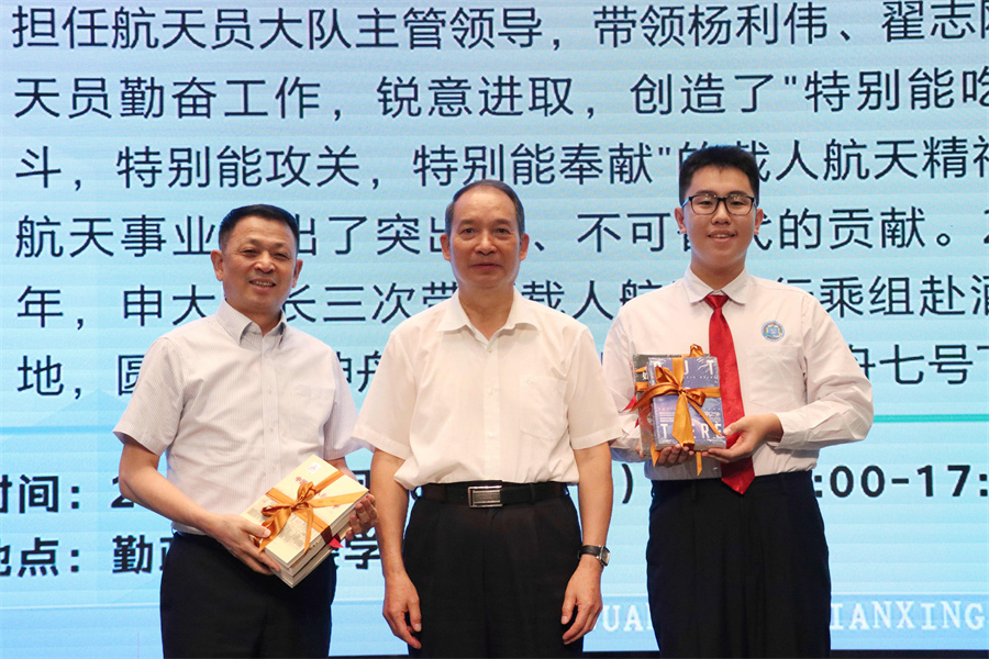 （申行运大校向学校赠送航天科普书籍，彭建平校长、罗志轩同学代表学校接受赠书。）.jpg